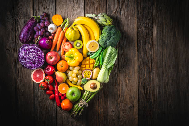 Vegetables and fruit with heart shape as concept of cardiovascular health on wooden rustic table